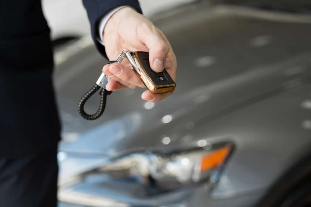 a car dealer with a key in a car dealership close 2022 02 17 20 16 12 utc