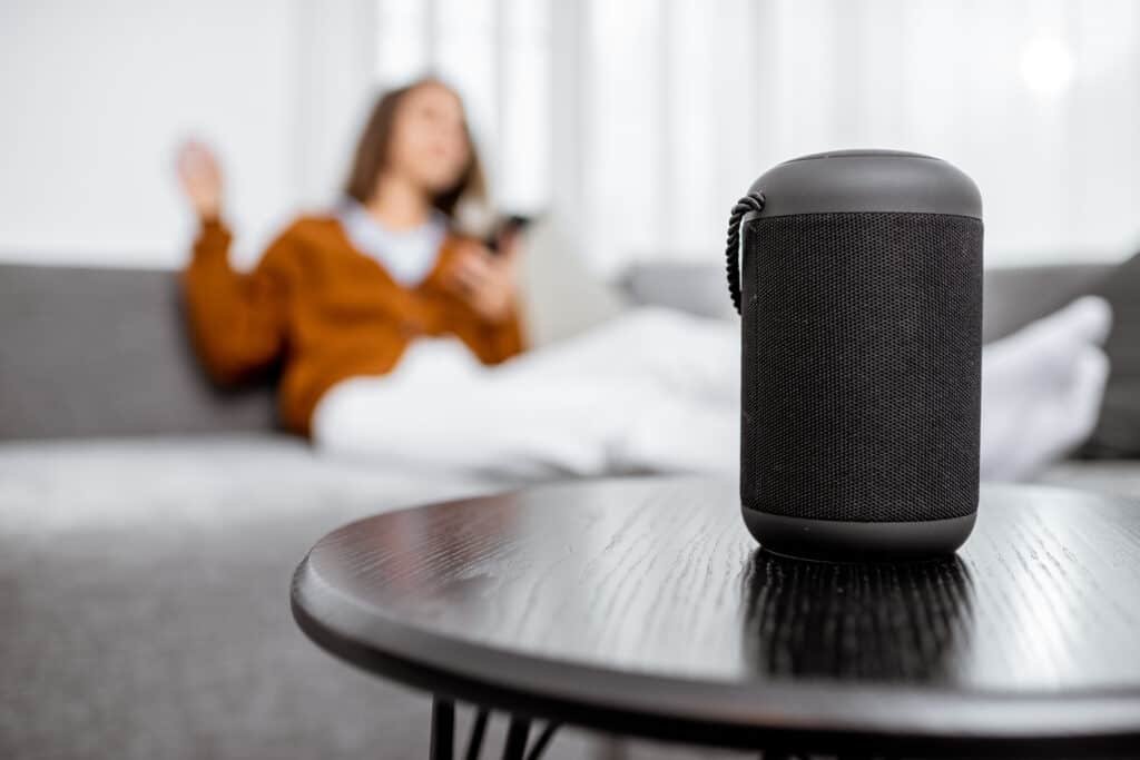 A woman instructing a IoT device from a sofa, in a secure home environment