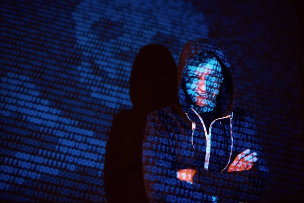 Cyber Criminal in a hood as part of the 7 types of cyber threat