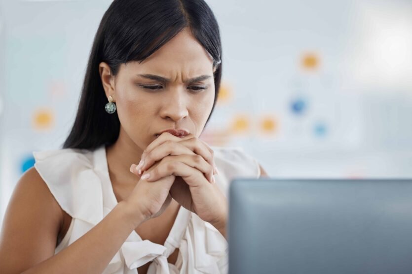 A young girl frowning whilst trying to spot a Phishing email on her laptop - Click on link to connect to the blogpost - How to stop phishing emails