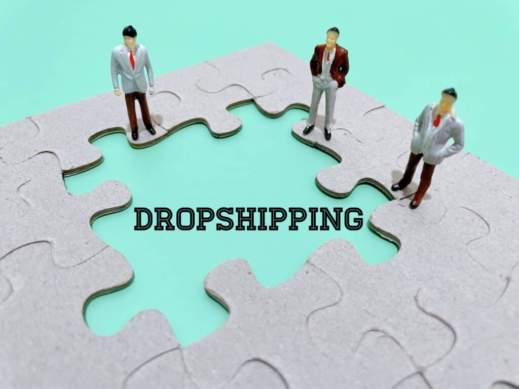 Three persons on a jigsaw with the word Dropshipping in the middle