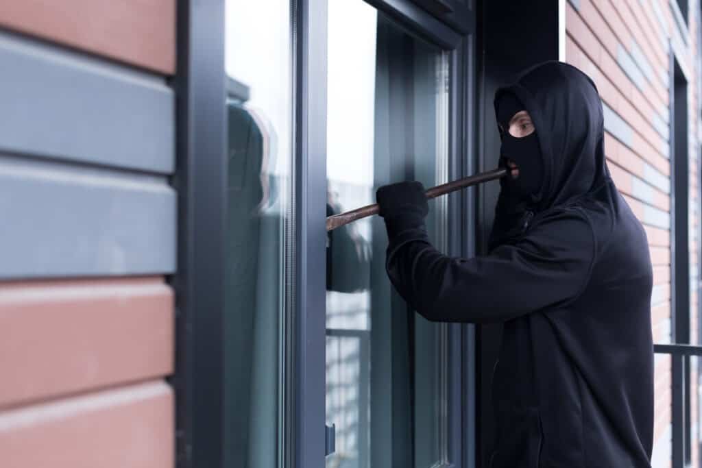 A burglar testing Window Security, as he tries to break into a window and get into the apartment for robbery