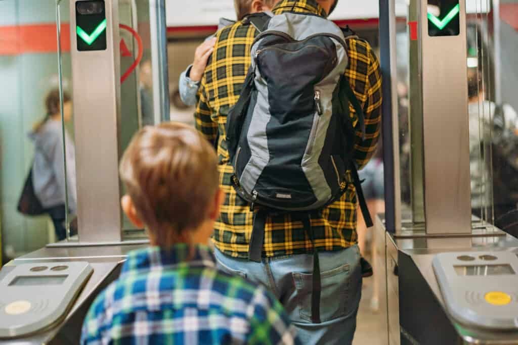 Man with children going through the ticket barrier at subway station. High quality photo