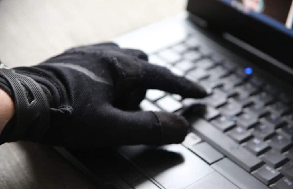 A closeup of a person in gloves using the computer - concept of cybersecurity and threat of getting hacked