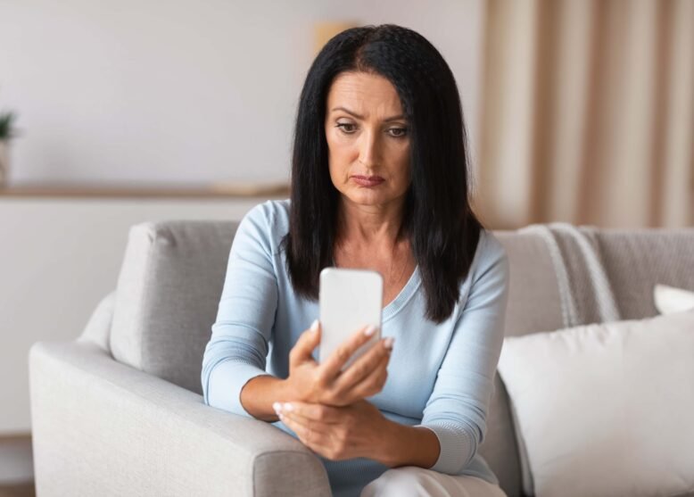 Click on the pciture of a mature woman on her smart phone to connect to the blog - social media scams