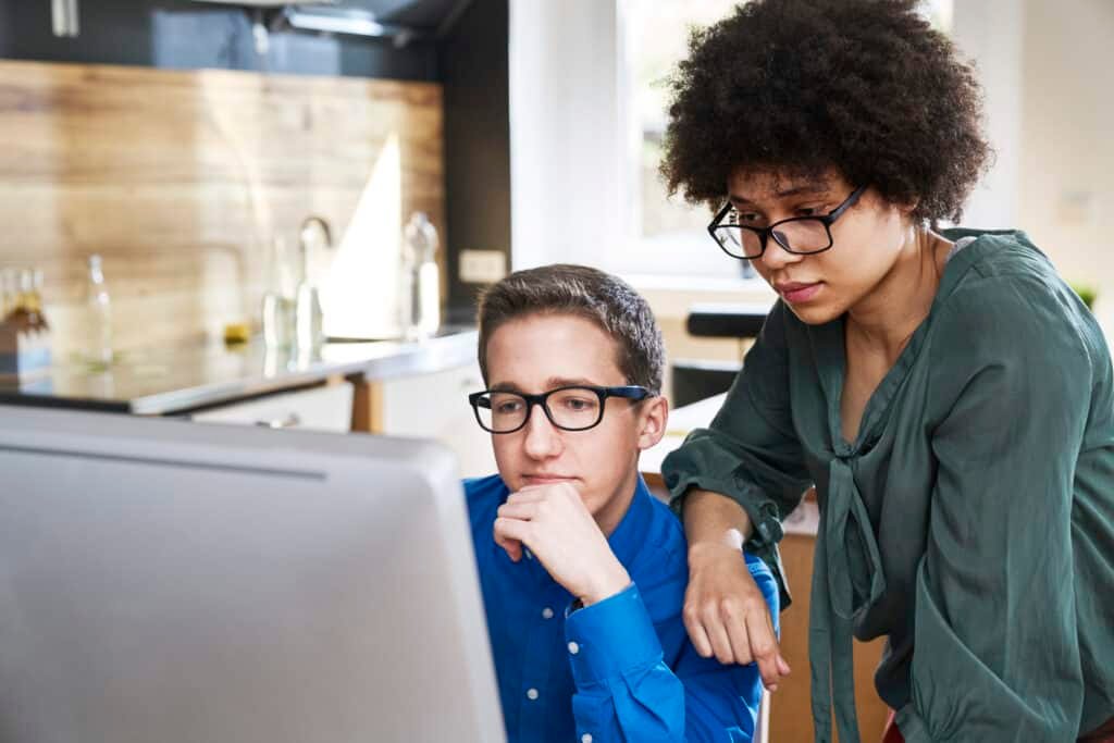 A couple looking at computer at home monitoring thier online accounts