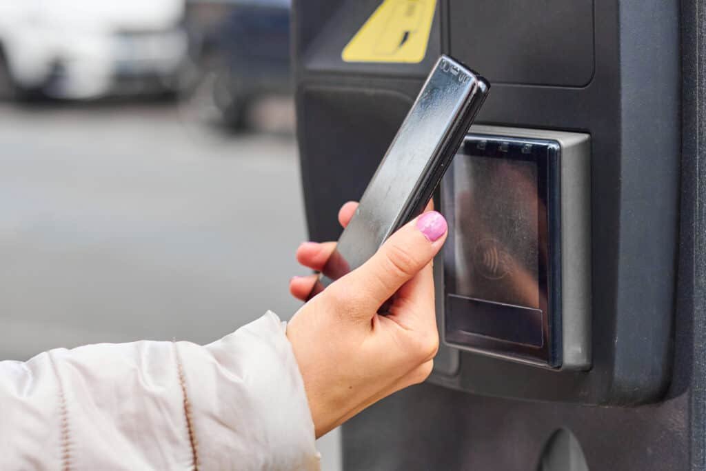 Smartphone payment with NFC technology for public parking with copy space. Contactless payment concept - Protecting agaist a Parking App Scam.