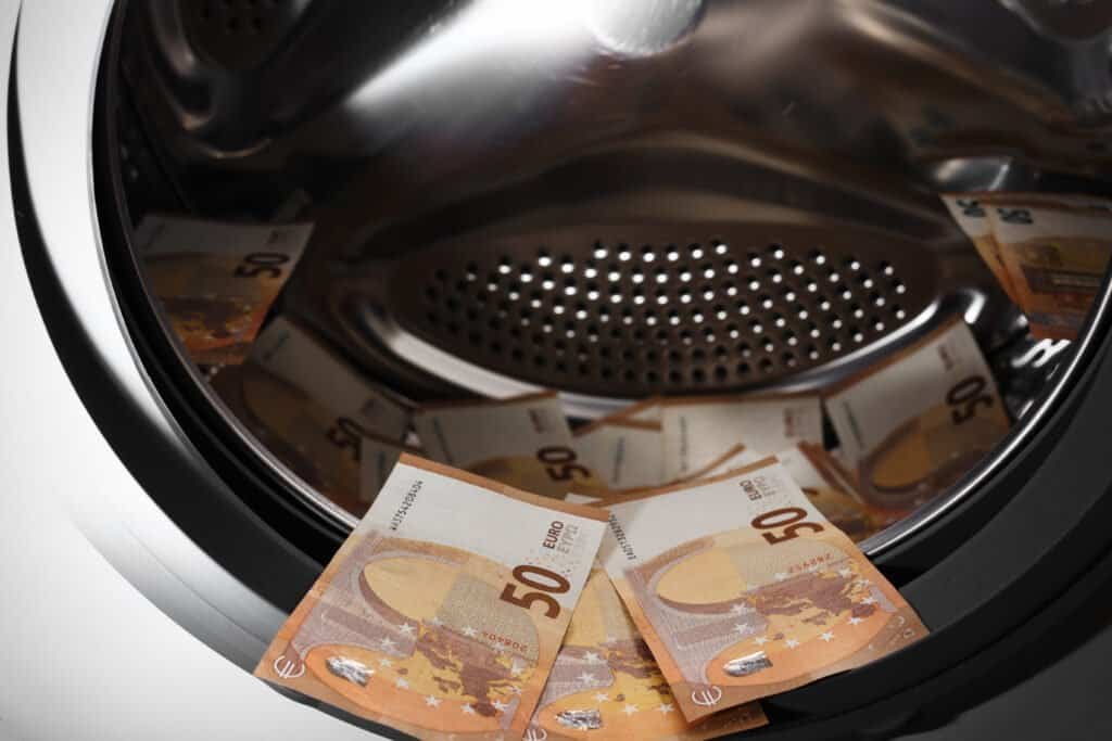 50 euro banknotes inside washing machine. Money laundering symbol. Tax evasion. Illegal financial transactions.