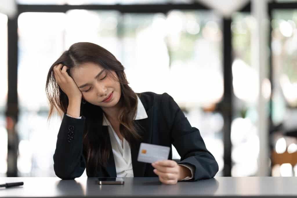 Unhappy young asian female buyer concerned she has been asked to pay for goods up front. Concerned she is a victiming of parcel delivery scamming