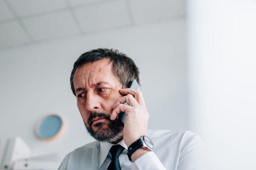 Click on image of concerned middle aged man on smart phone to connect to the blog - Caller ID Spoofing