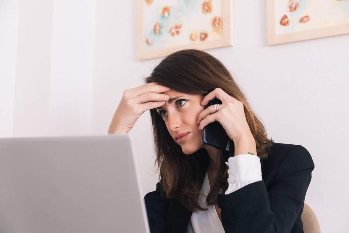 Click on image of a concerned woman on the phone in front of a laptop to connect to the blogpost Geek Squad Scam