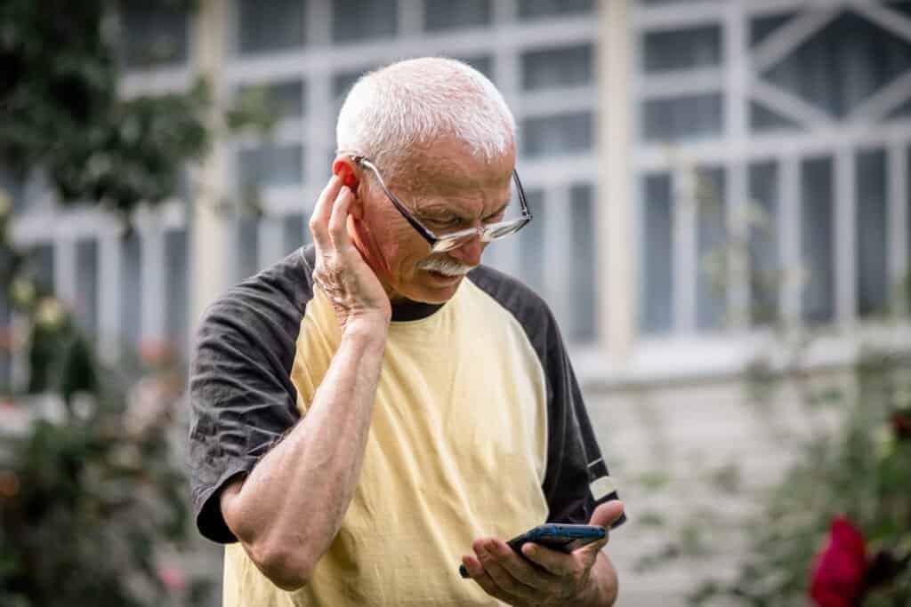 An old man using his smart phone to track a missed royal mail delivery package.