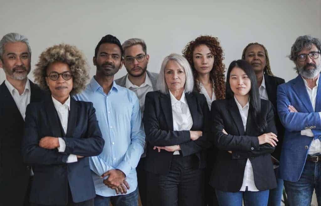 Group of multi generational people looking serious on camera inside coworking office