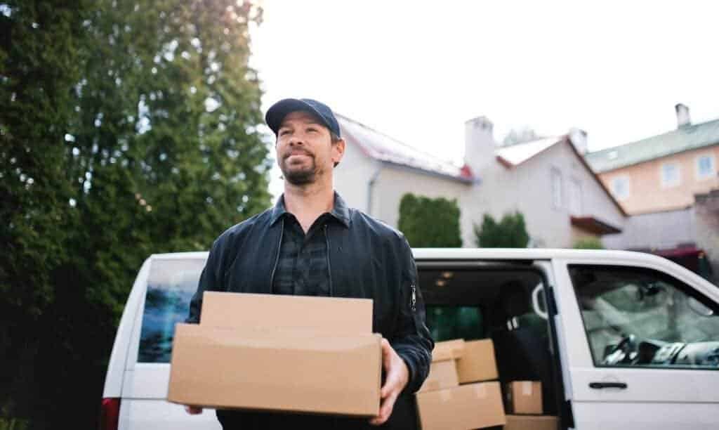 A delivery man courier delivering parcel box in town from Vinted