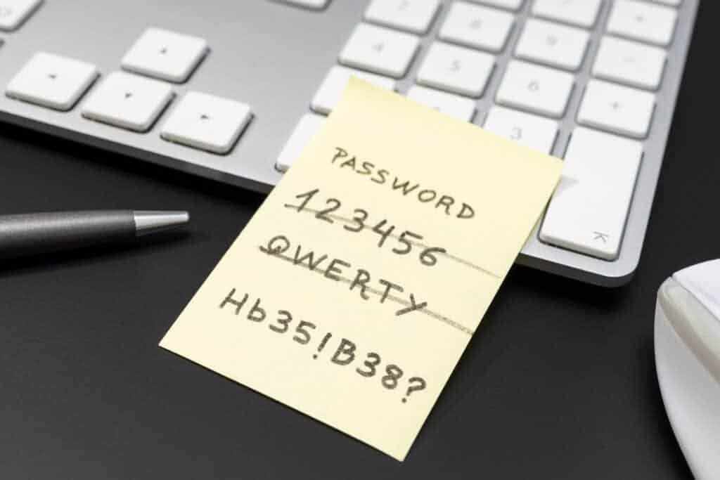 Strong and weak easy Password written on yellow sticky note lying on computer keyboard.