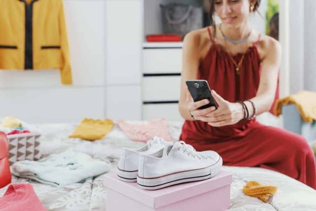 Fashionable woman decluttering her wardrobe, she is selling her used clothes and accessories online