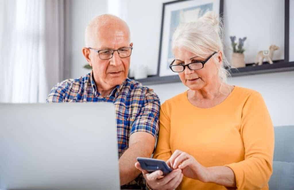 Worried senior couple checking thier investments using laptop at home